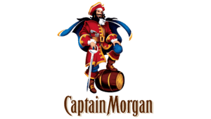Brandul Captain Morgan este unul dintre cele mai recunoscute și populare nume din lumea romului, având o istorie care începe în anul 1944. Fondat în Jamaica de Seagram Company Ltd., brandul este acum deținut de Diageo, un gigant în industria băuturilor alcoolice. Numele „Captain Morgan” este inspirat de Sir Henry Morgan, un corsar galez din secolul al XVII-lea care a devenit guvernator al Jamaicaii și este cunoscut pentru aventurile sale maritime în Caraibe. Captain Morgan este cel mai bine cunoscut pentru variantele sale de rom cu aromă de condimente, precum Captain Morgan Original Spiced Gold și Captain Morgan Dark Rum, dar și pentru alte tipuri precum rom alb și rom negru. Original Spiced Gold, una dintre cele mai populare alegerei, este faimos pentru gustul său distinct de vanilie, condimente și note de caramel, fiind adesea consumat ca mixer în diverse cocktailuri. Marketingul brandului este cunoscut pentru abordarea sa jovială și plină de aventură, centrându-se adesea pe imaginea lui Sir Henry Morgan. Campaniile publicitare ilustrează frecvent o lume plină de distracție, aventură și camaraderie, un ecou al vieții pe mare a piratilor. Pe lângă calitatea și varietatea romurilor sale, Captain Morgan se distinge prin ambalajul atractiv și prin prezența sa puternică în barurile și casele de pe glob, fiind un pilon de bază în arta mixologiei moderne.
